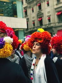 Portrait of woman with red flowers in city