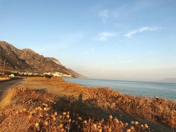 Scenic view of beach and mountains against sky