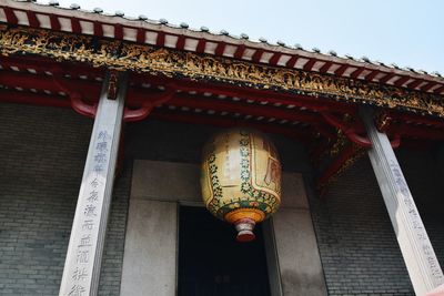 Low angle view of illuminated lantern hanging on roof of building
