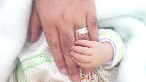 Cropped image of hand touching baby