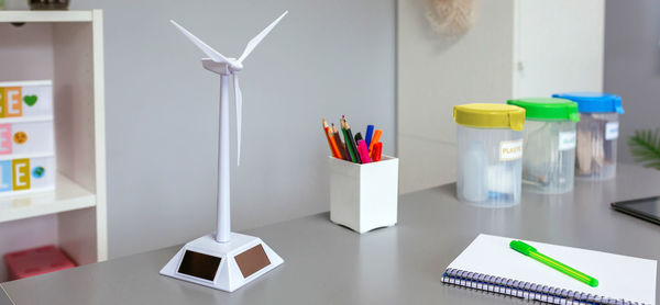 Solar windmill and selective trash bins over desk in classroom