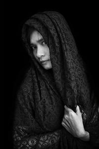 Portrait of woman with scarf against black background