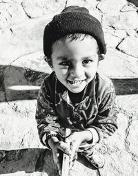 Portrait of cute boy smiling while standing outdoors