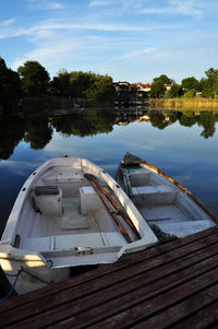 Boats moored in lake against sky