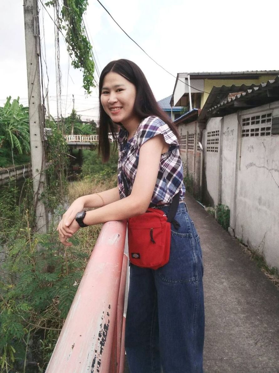 one person, casual clothing, lifestyles, real people, looking at camera, young adult, three quarter length, smiling, leisure activity, young women, architecture, happiness, standing, portrait, built structure, day, building exterior, side view, outdoors, beautiful woman, hairstyle