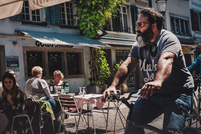 Friends sitting on table at sidewalk cafe