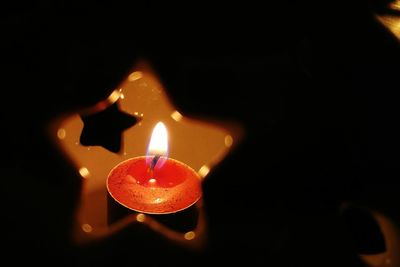 Close-up of lit candle in dark room