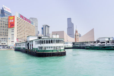 Scenic view of sea by buildings against clear sky