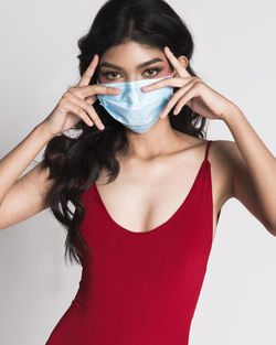 Portrait of beautiful woman wearing mask and swimwear over white background