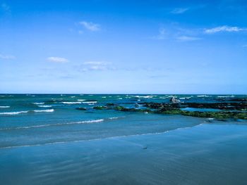 Scenic view of beach against blue sky