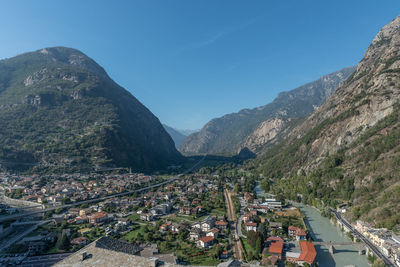 High angle view of townscape by mountain against sky in italy