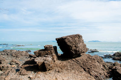 Rock formation on beach against sky