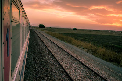 Railroad tracks against sky during sunset