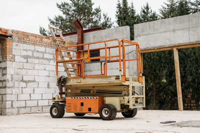 Scissor lift platform on a construction site. building concreate house with mobile transportation