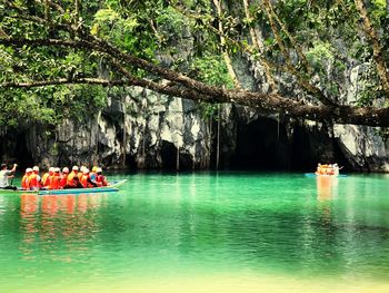 People in boat against trees