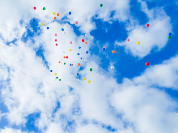 Low angle view of balloons against sky