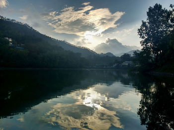 Scenic view of lake by trees against sky