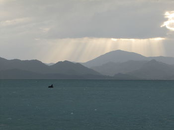 Scenic view of sea and mountains against sky