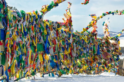 Prayer flags with tibetan mantras in wind at snowy temple complex, asian culture at local monastery