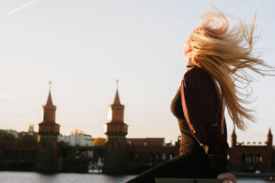 Rear view of young woman by river