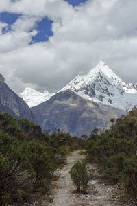 Scenic view of snowcapped mountains against cloudy sky