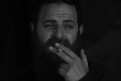 Close-up portrait of mid adult man over black background