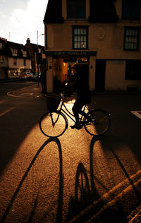 Shadow of man riding bicycle on road