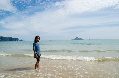 Woman standing on beach against sky