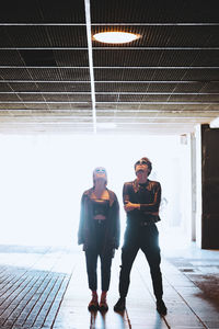 Couple looking up standing in illuminated underpass