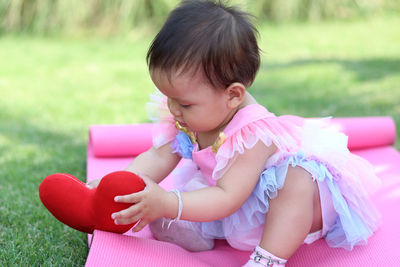 Cute girl sitting on pink face