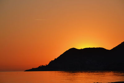 Scenic view of silhouette of hill against sky during sunset