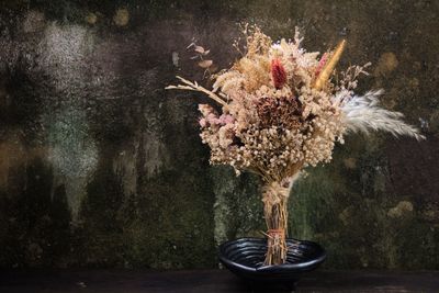 Close-up of flower vase against wall