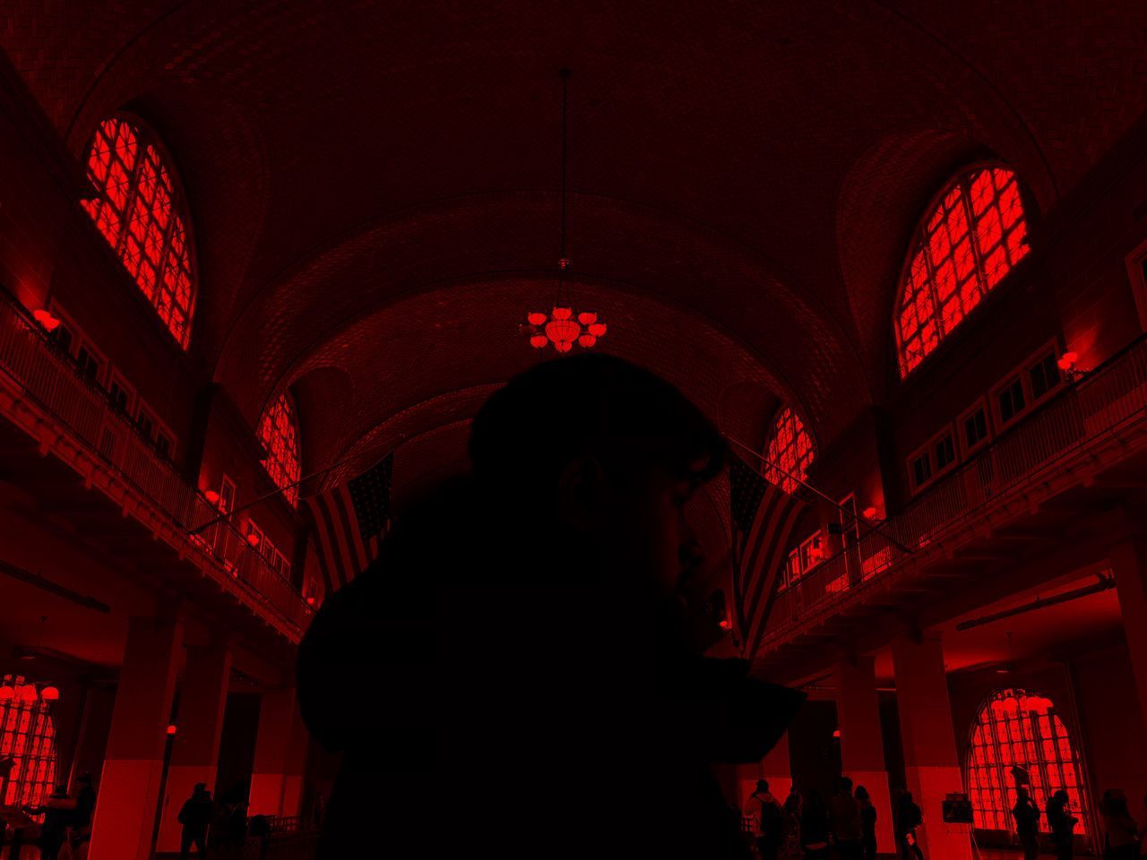 REAR VIEW OF SILHOUETTE WOMAN STANDING AT ILLUMINATED RED BUILDING