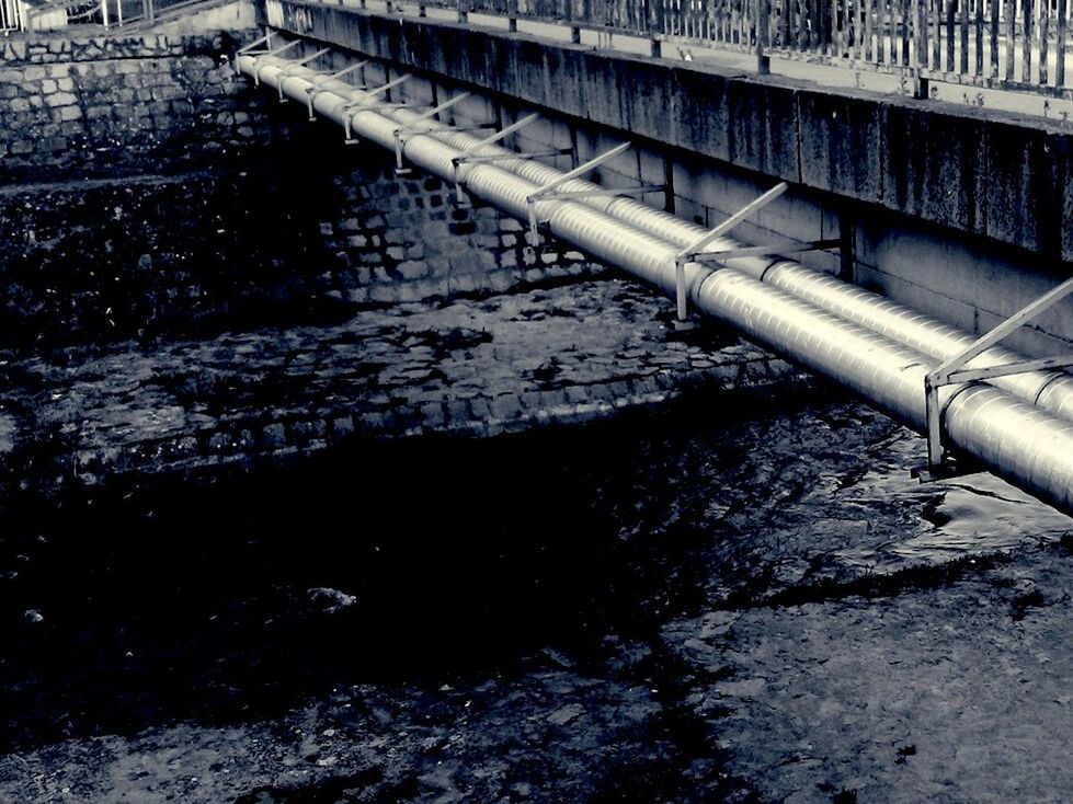 water, built structure, architecture, connection, bridge - man made structure, railing, high angle view, metal, river, day, outdoors, transportation, reflection, part of, no people, building exterior, wet, steps, pipe - tube, cropped