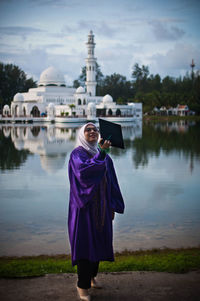 Full length of woman standing at temple against sky