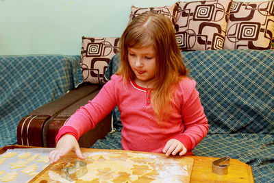 Girl preparing cookies while sitting at home