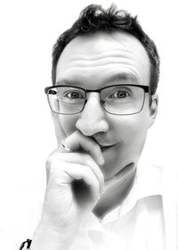 Portrait of young man wearing eyeglasses against white background