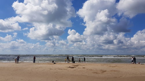 People on beach against sky