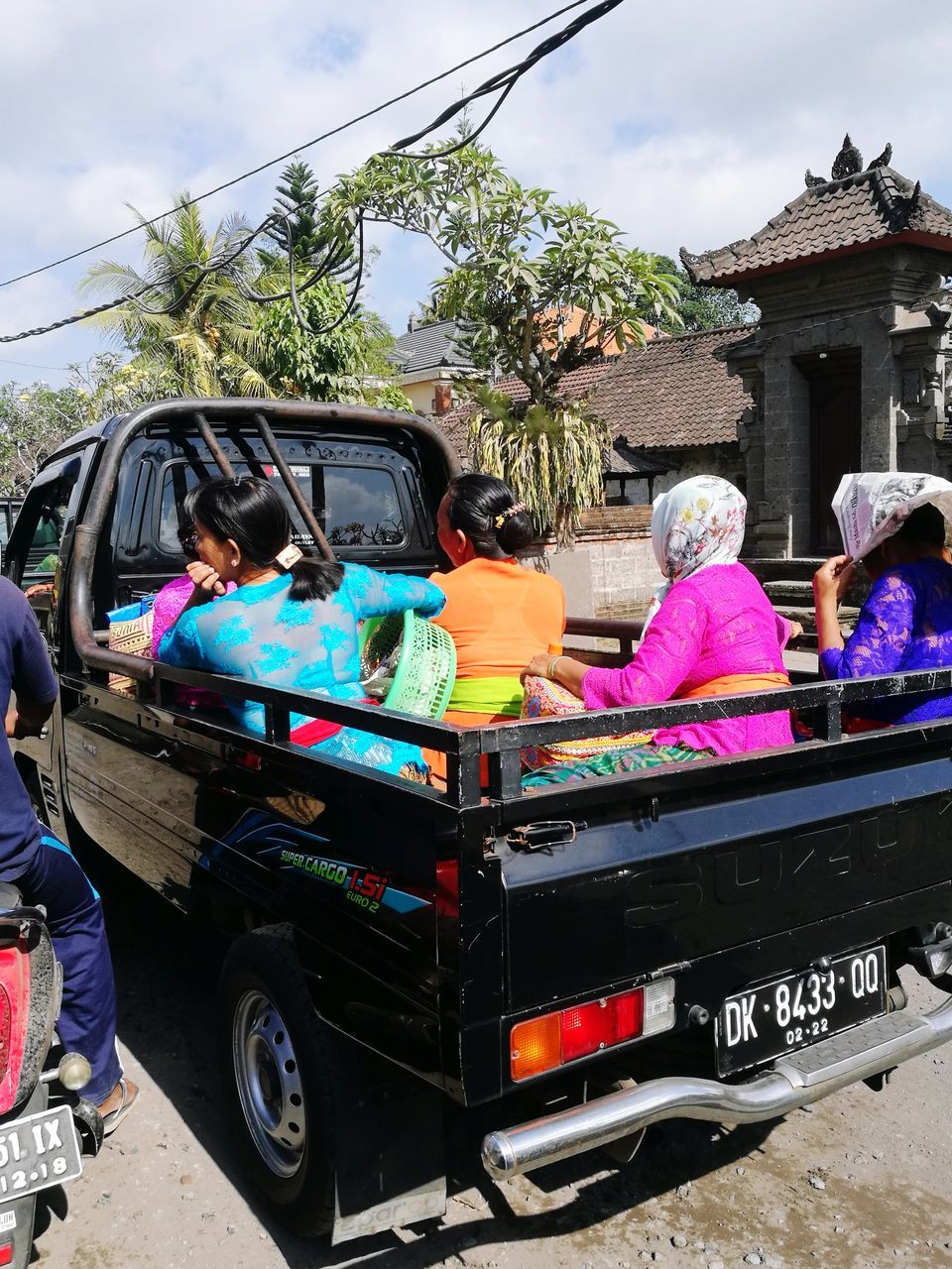 real people, transportation, mode of transport, day, land vehicle, car, men, outdoors, medium group of people, sitting, leisure activity, travel, women, lifestyles, architecture, building exterior, tree, sky