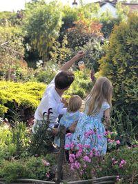 Rear view of women with flowers on plants