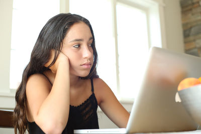 Close-up of young woman using mobile phone at home