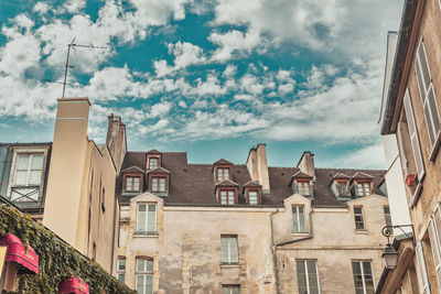 Low angle view of buildings in town against sky