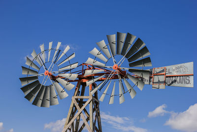 Low angle view of traditional windmill against blue sky