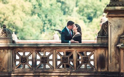 Couple kissing by railing on footbridge