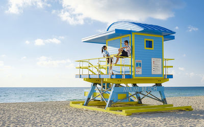 Lifeguard hut on beach against sky