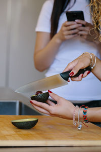 Midsection of woman using laptop on table