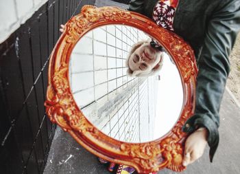 Midsection of woman looking in mirror