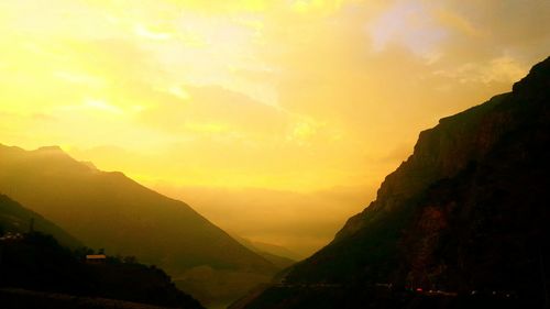 Scenic view of mountains against sky at sunset