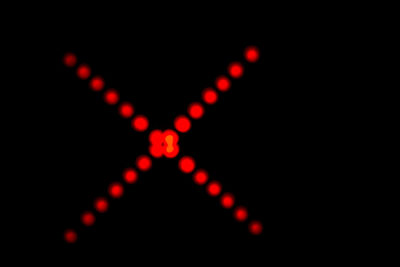 Defocused image of illuminated lights against black background