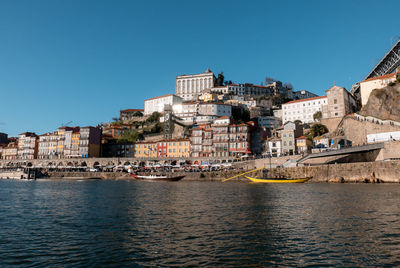 River amidst buildings in city against clear sky